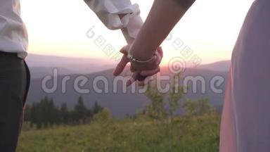 一对互相握手。 这对夫妇在夕阳下牵手的<strong>近景</strong>。 浪漫的<strong>户外</strong>景观。